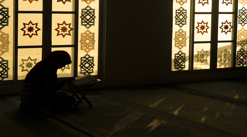 Muslim woman praying reciting Quran